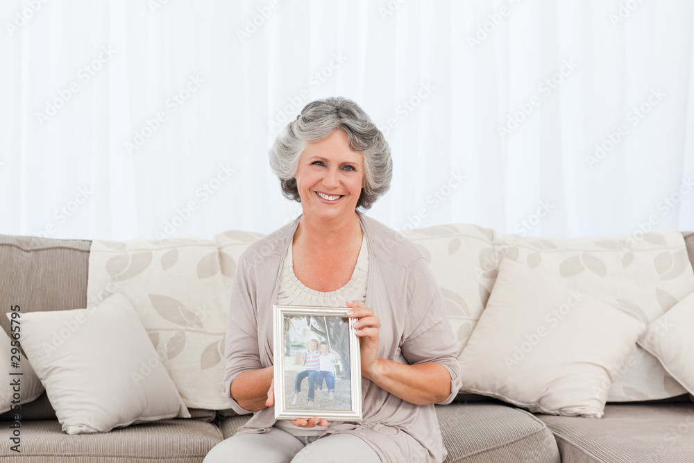 Smiling woman showing a picture of her grandchild Smiling woman showing a picture of her grandchild