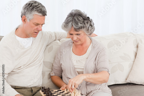 Couple playing chess on their sofa