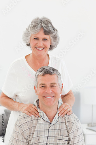 Retired woman giving a massage to her husband at home
