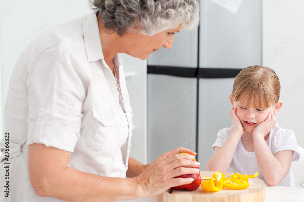 Little girl looking at her grandmother who is cooking Little girl looking at her grandmother who is cooking