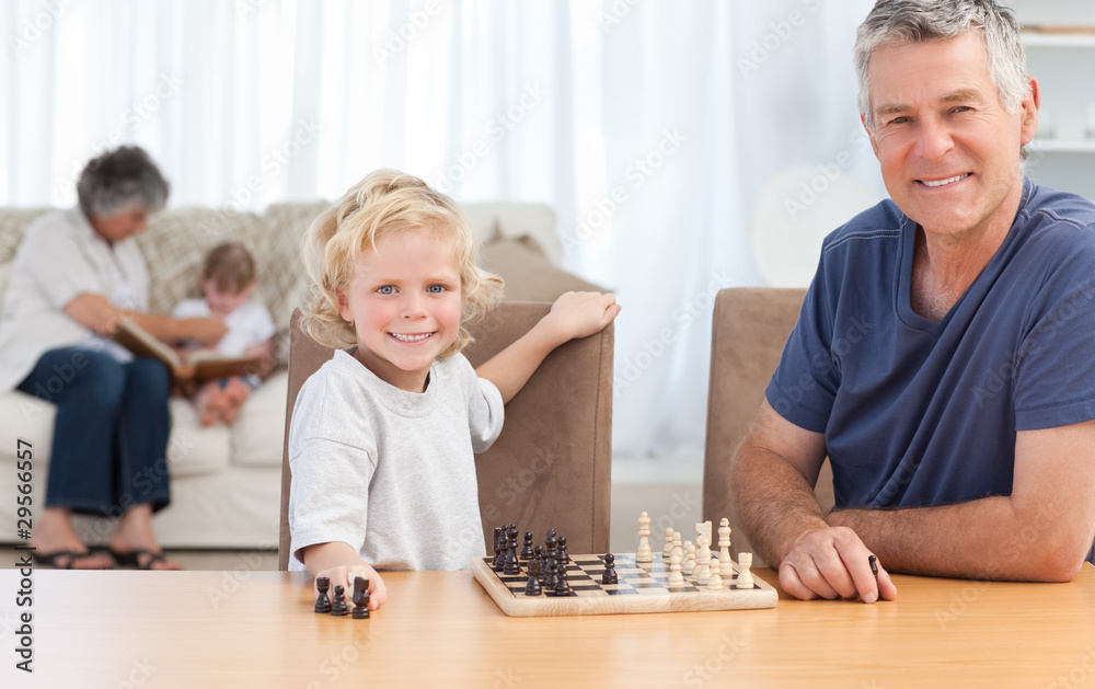 Young boy playing chess with his grandfather Young boy playing chess with his grandfather