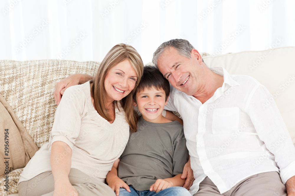 A little boy with his grandparents looking at the camera