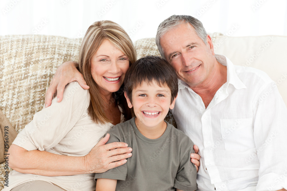 A little boy with his grandparents looking at the camera