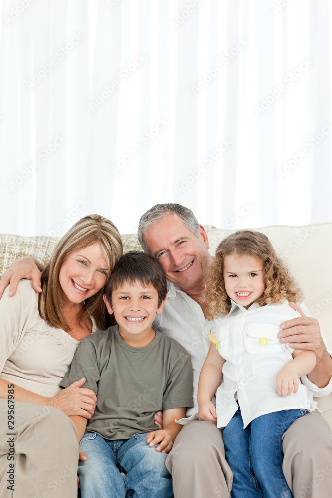 A happy family on their sofa looking at the camera