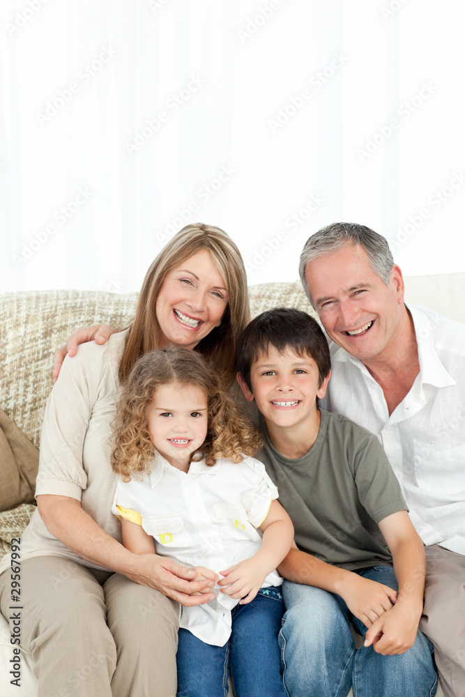 A happy family on their sofa looking at the camera A happy family on their sofa looking at the camera
