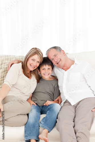 A little boy with his grandparents looking at the camera