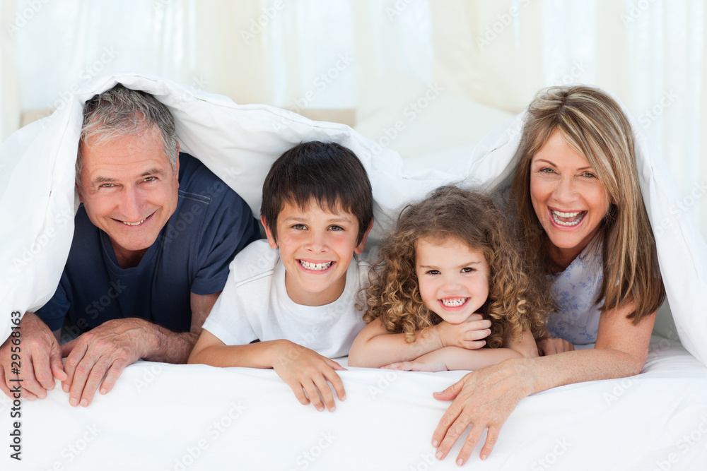 Family in their bedroom looking at the camera at home Family in their bedroom looking at the camera at home