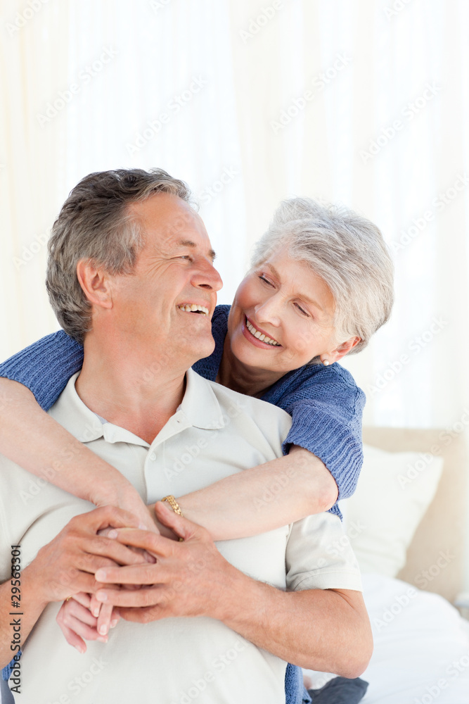 Senior couple hugging on their bed Senior couple hugging on their bed