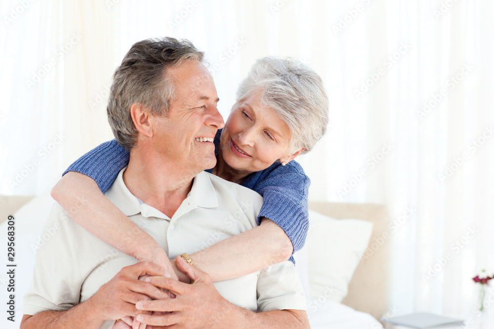 Senior couple hugging on their bed Senior couple hugging on their bed