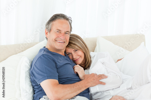 Senior couple lying down on their bed