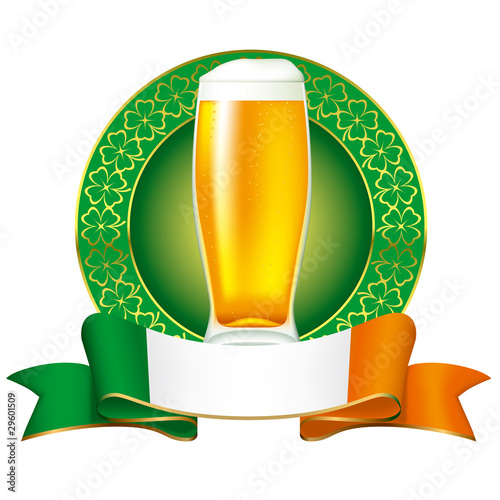 A glass of beer with Irish flag and clover ornament.