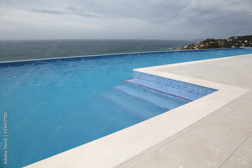 Modern swimming-pool with view towards the ocean