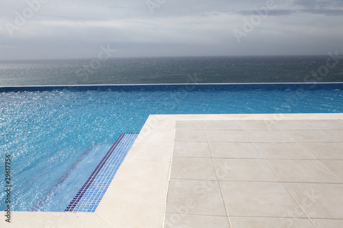 Modern swimming-pool with view towards the ocean © goodluz