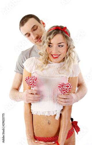 Fotografi young happy couple with candies in the shape of hearts