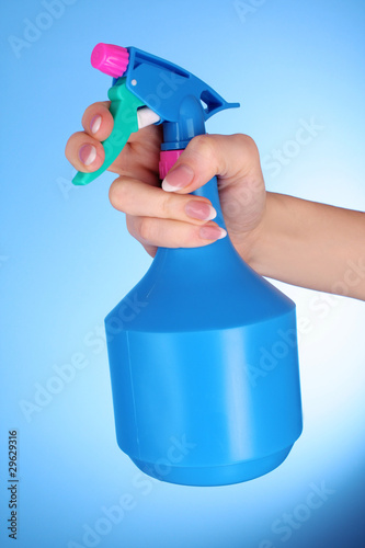 Hands with spray on blue background