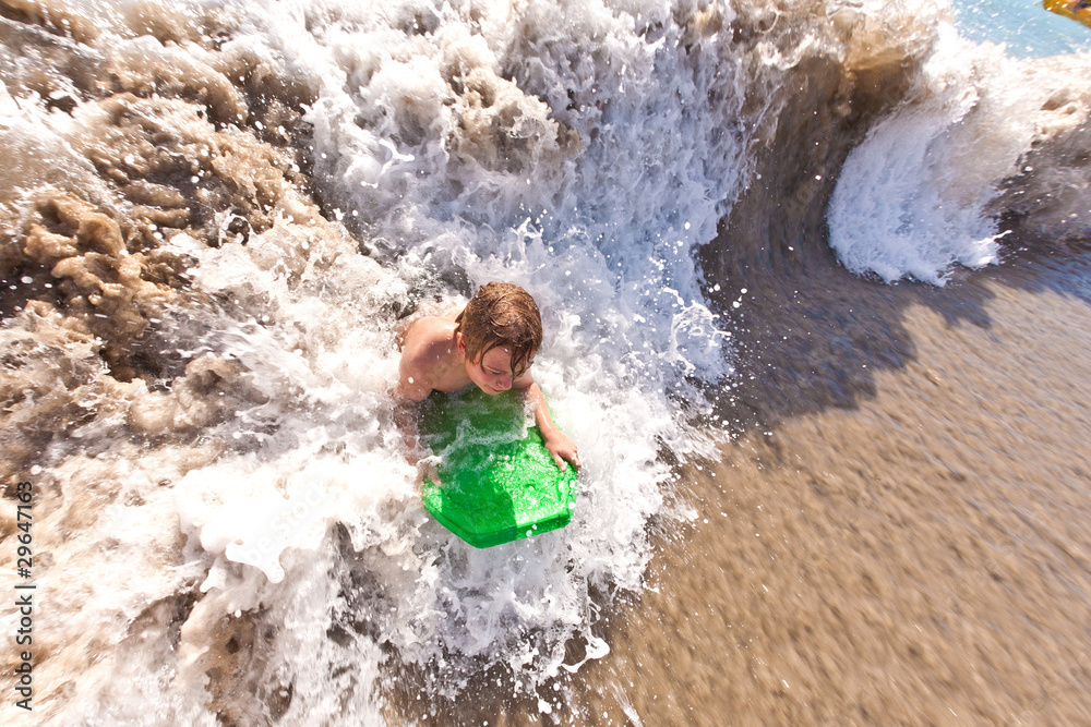 Fototapeta premium young boy surfes in huge waves