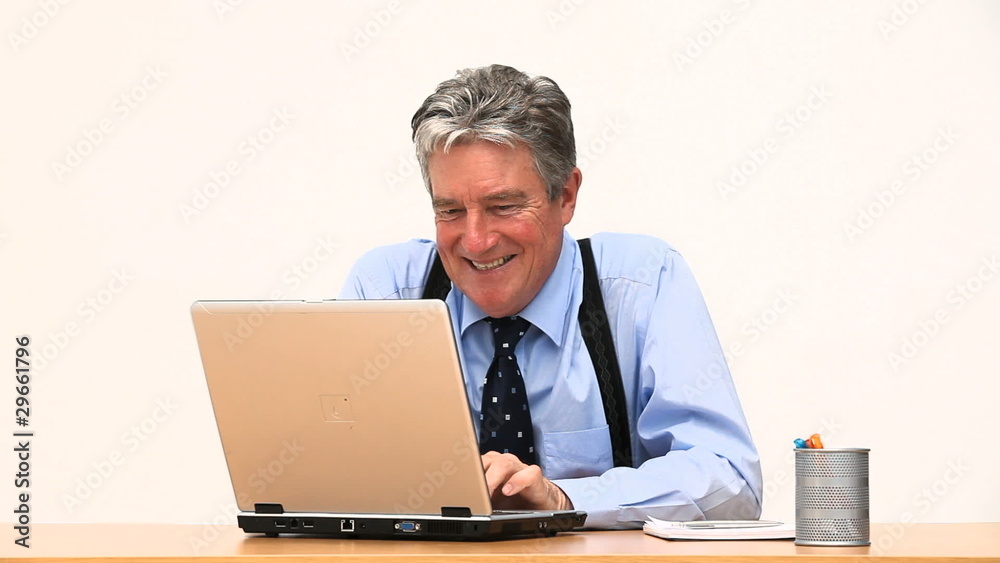 An elderly business man working at a desk An elderly business man working at a desk