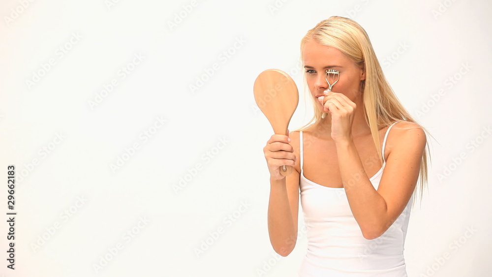 Woman putting on make up against white blackground Woman putting on make up against white blackground