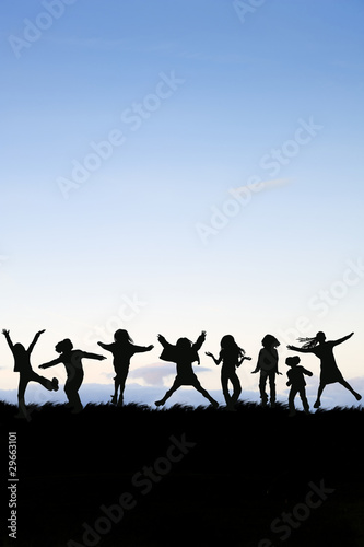 Silhhouette of group of kids playing around and jumping