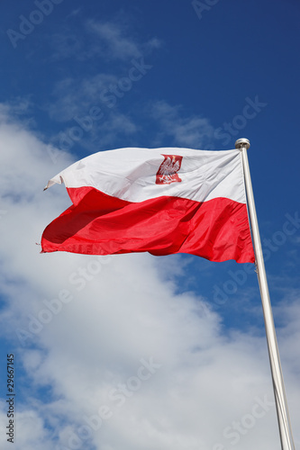 Polish national flag against the blue sky.
