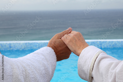 Senior couple relaxing in long chairs photo