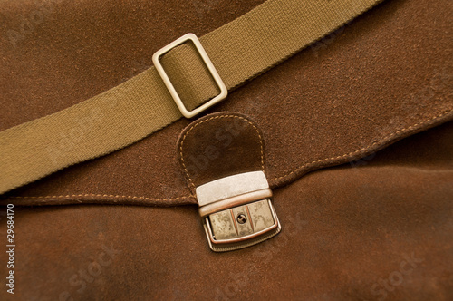 Buckle and thong on a brown pressed leather bag photo