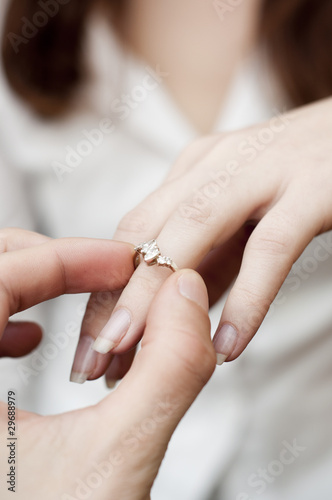 situation of inserting engagement ring into a finger