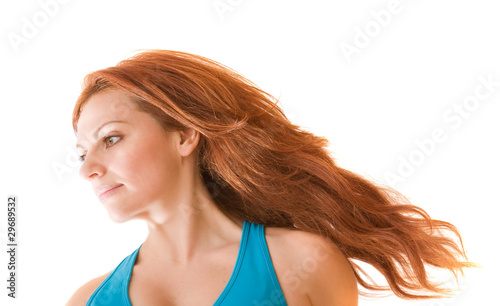 charming red-haired young fit woman with her hair flying