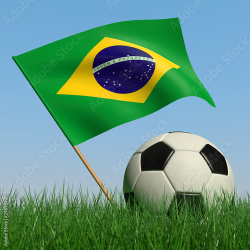 Soccer ball in the grass and the flag of Brazil