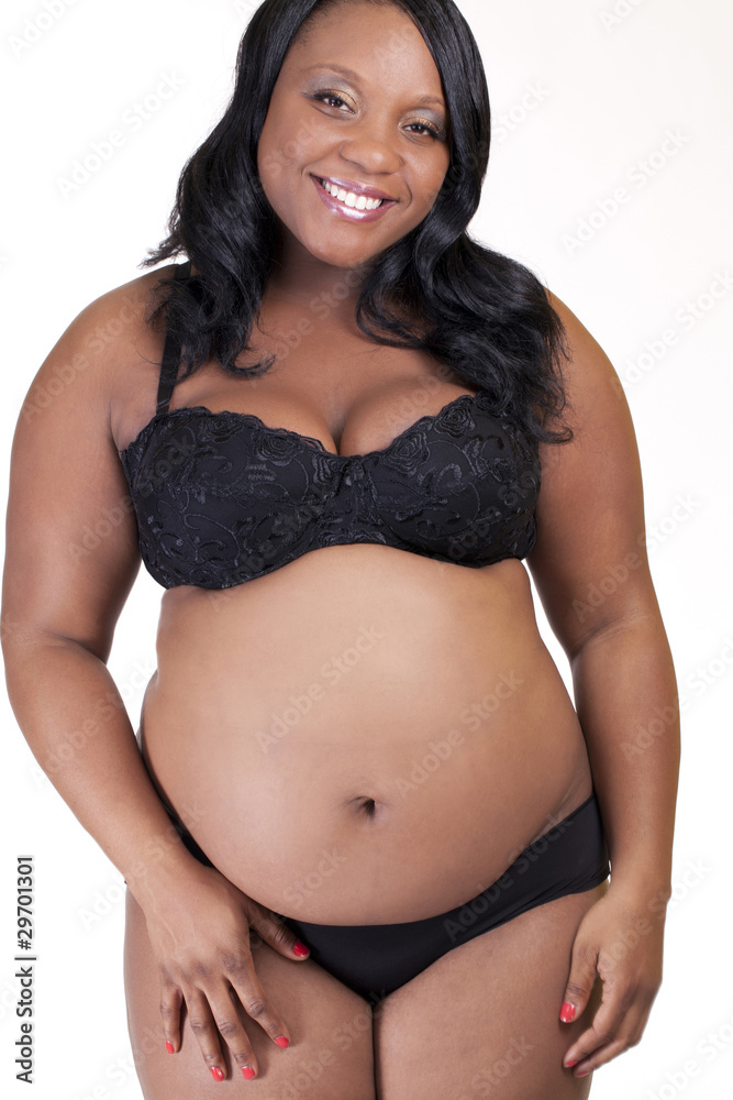 Young Black Pregnant woman standing in lingerie Stock Photo