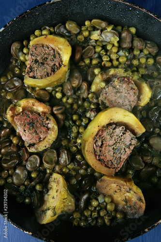 zucchini filled meat cooked with peas over blue table