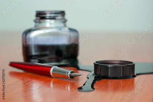 black ink spill near red pen on  table