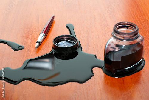 black ink spill near red pen on  table