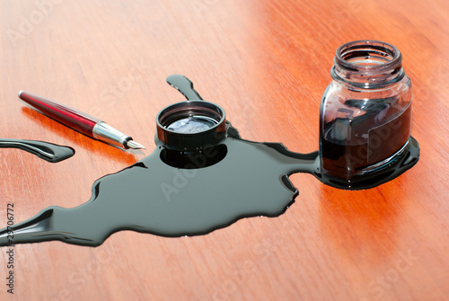 black ink spill near red pen on  table