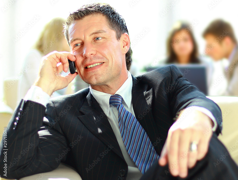 Concentrating businessman on call, coworkers talkling Concentrating businessman on call, coworkers talkling