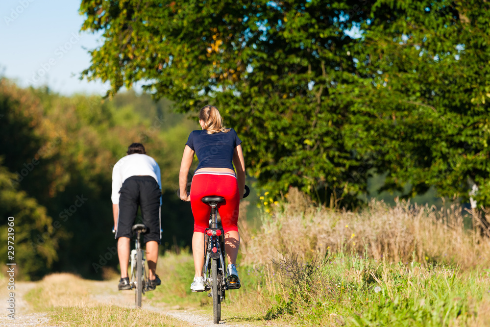 Man and woman exercising with bicycle Man and woman exercising with bicycle