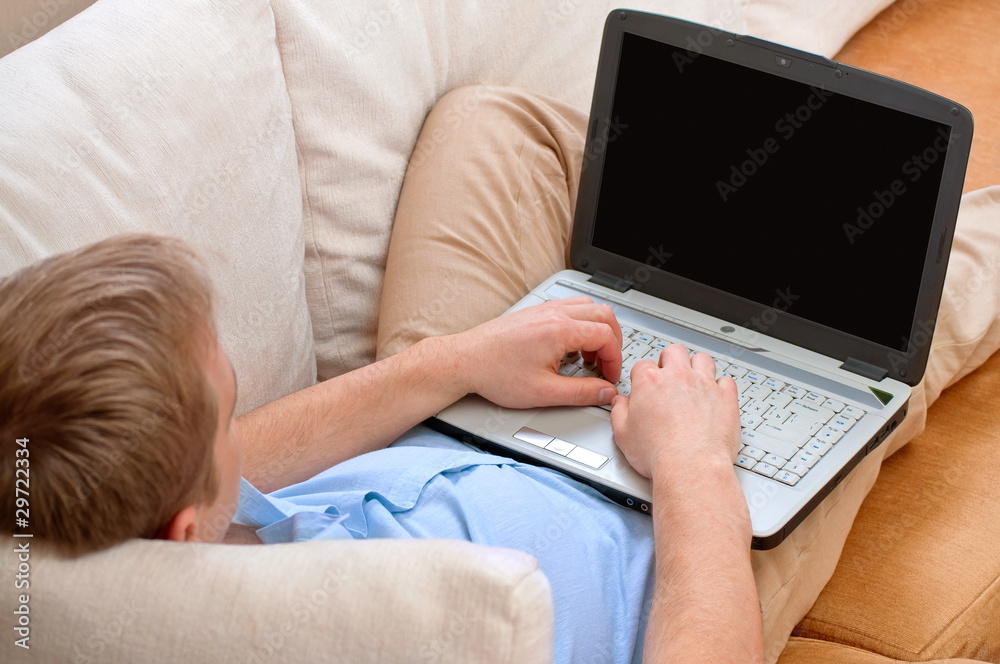 young man using a laptop at home young man using a laptop at home