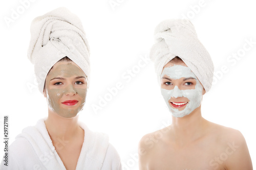 Young happy women with facial clay mask