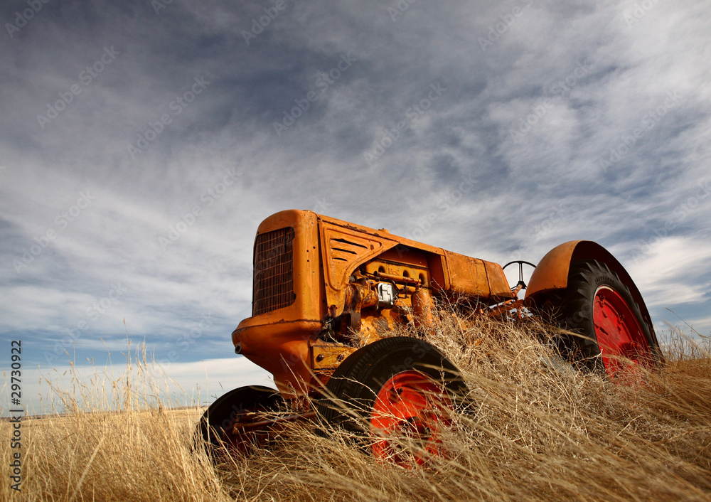 Obraz premium Tumbleweeds piled against abandoned tractor