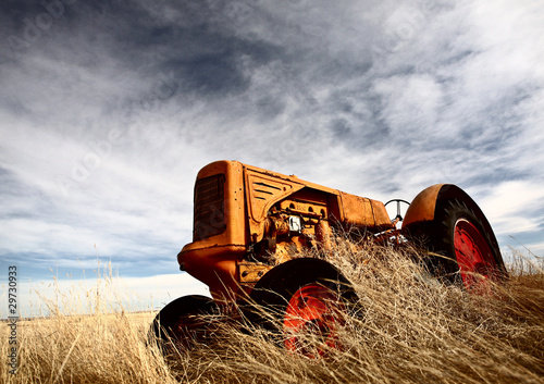 Tumbleweeds piled against abandoned tractor