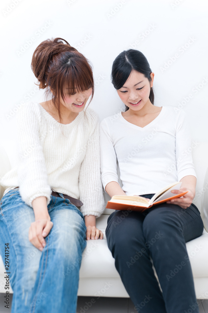 two beautiful asian women reading a book two beautiful asian women reading a book