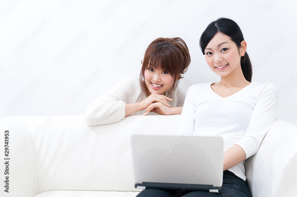 two beautiful asian women relaxing on the sofa