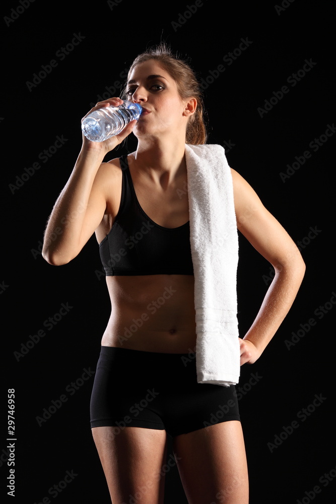 Young woman drinking bottled water after exercise Young woman drinking bottled water after exercise