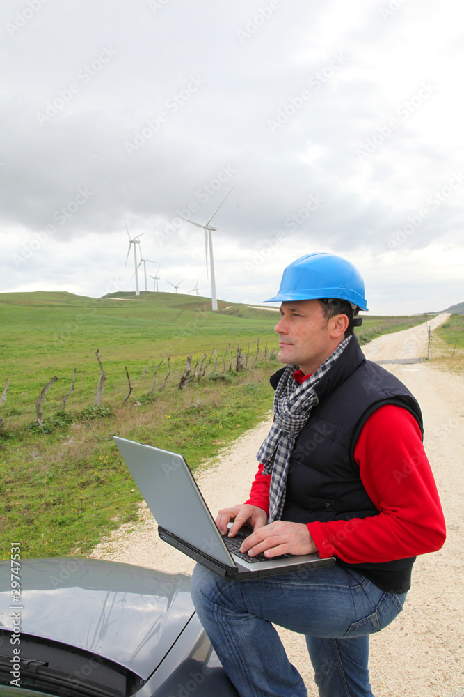 Engineer working on laptop computer in wind turbines field