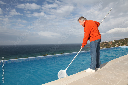 Senior couple cleaning swimming pool