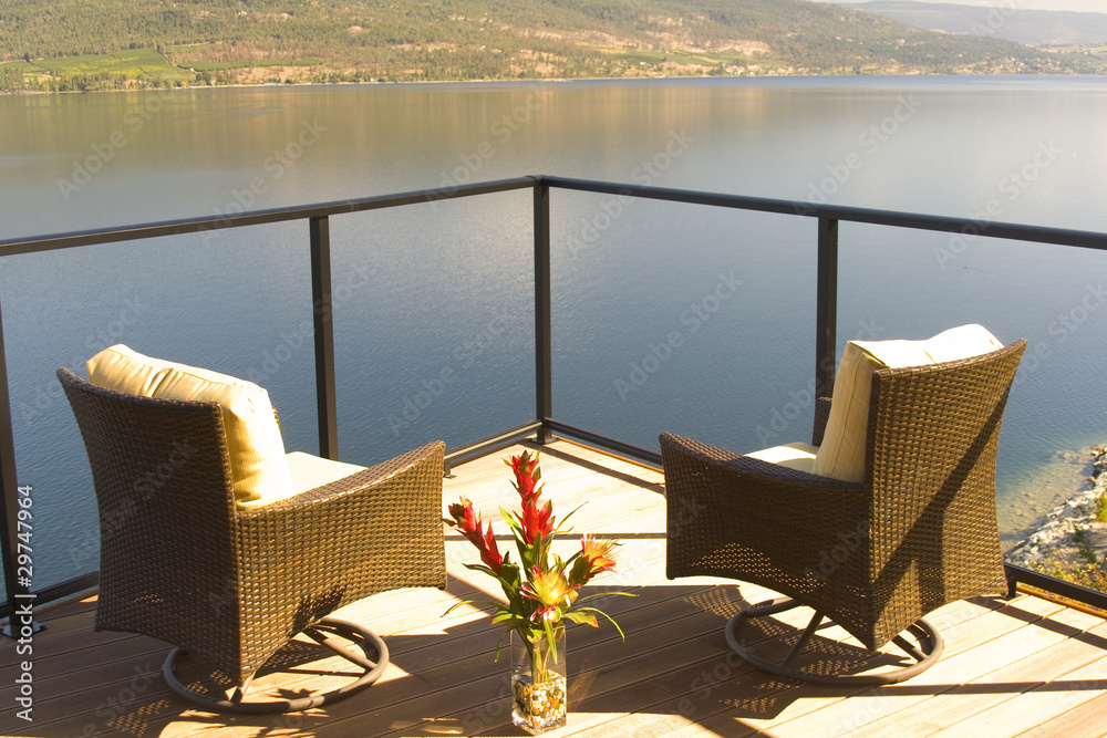 Fototapeta premium Two luxurious chairs on a lakefront sun deck