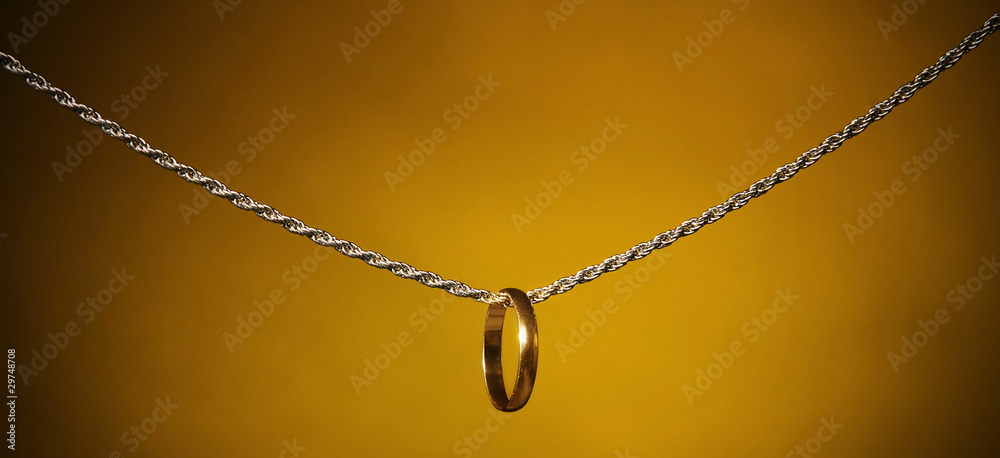 Fototapeta premium Gold ring on a silver chain;