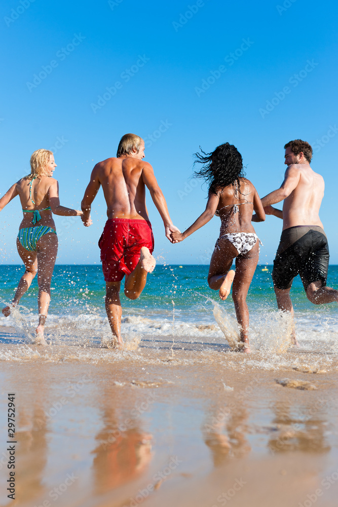 Freunde laufen im Urlaub am Strand