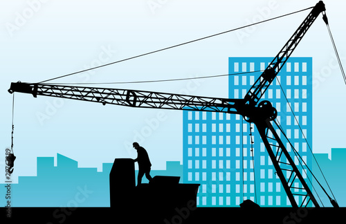 Silhouette of the building crane against a city