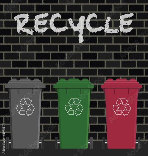 Recycling wheelie bins against a brick wall
